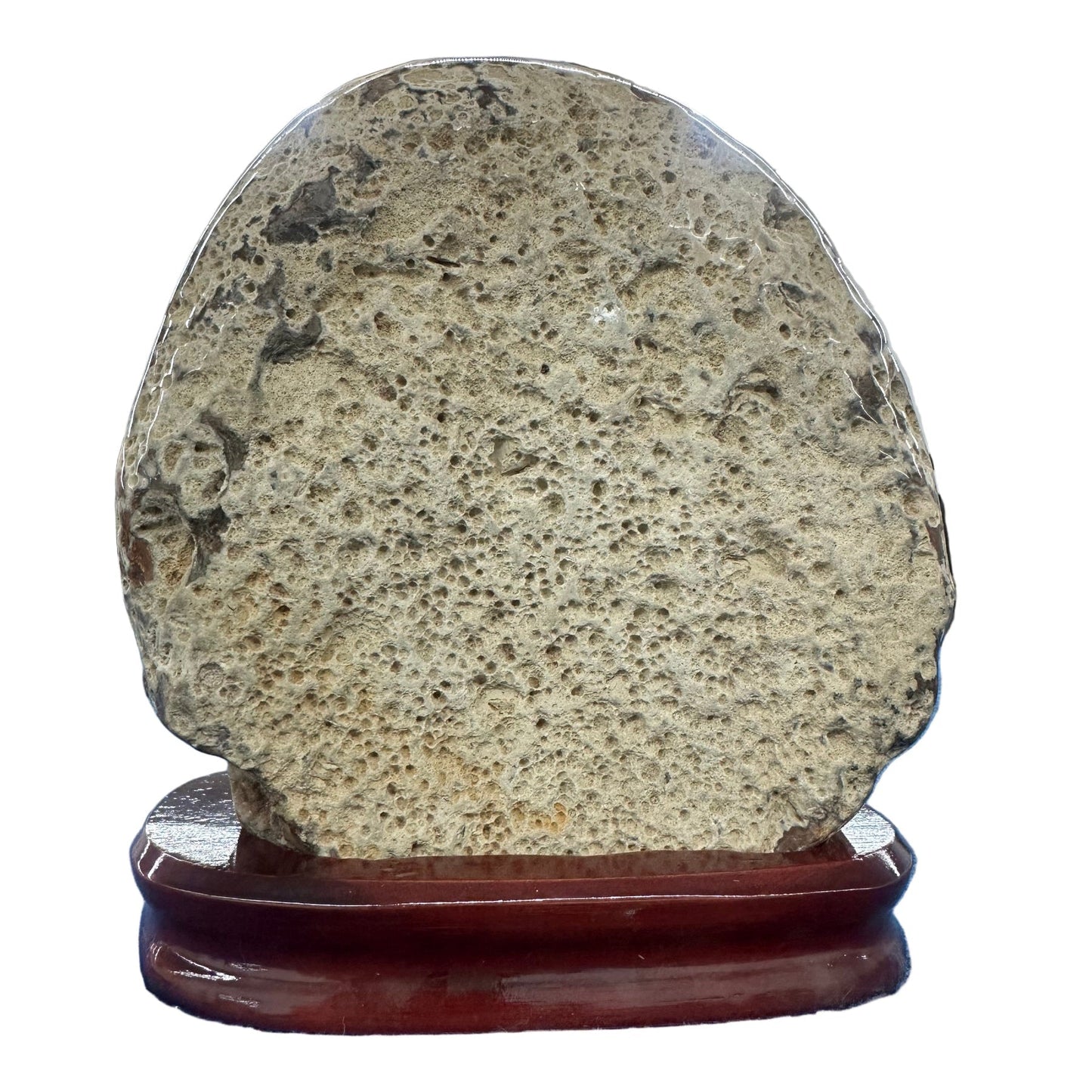 Round stone on a wooden stand against a blue and white tiled wall