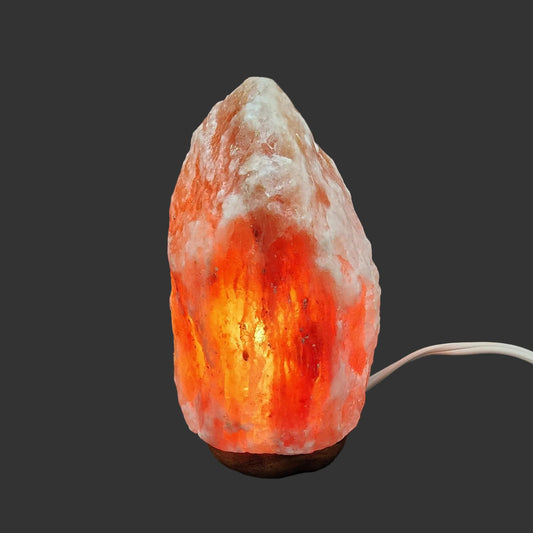 The front view of this pink Himalayan salt lamp, with the light turned on.