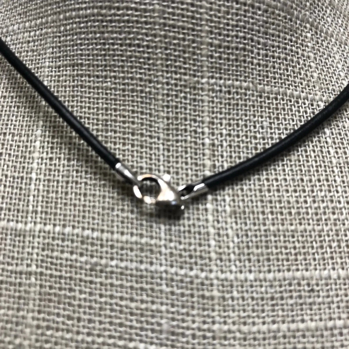 Clasp on black leather cord necklace