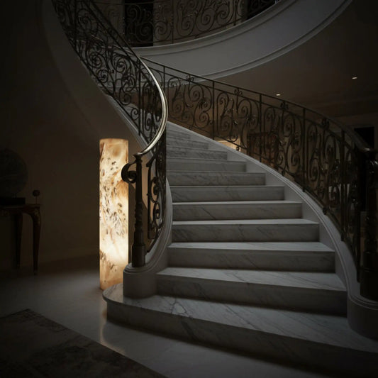 Onyx Pedestal Lamp Lighted 59 Inches Tall Natural Neutral Colors Of Cream, Brown, Tan, Gray, and next to a spiral staircase.