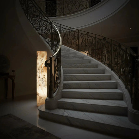 Onyx Pedestal Lamp Lighted 59 Inches Tall Natural Neutral Colors Of Cream, Brown, Tan, Gray, and next to a spiral staircase.