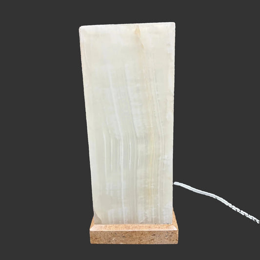 Front side of this onyx lamp, in front of a black background.