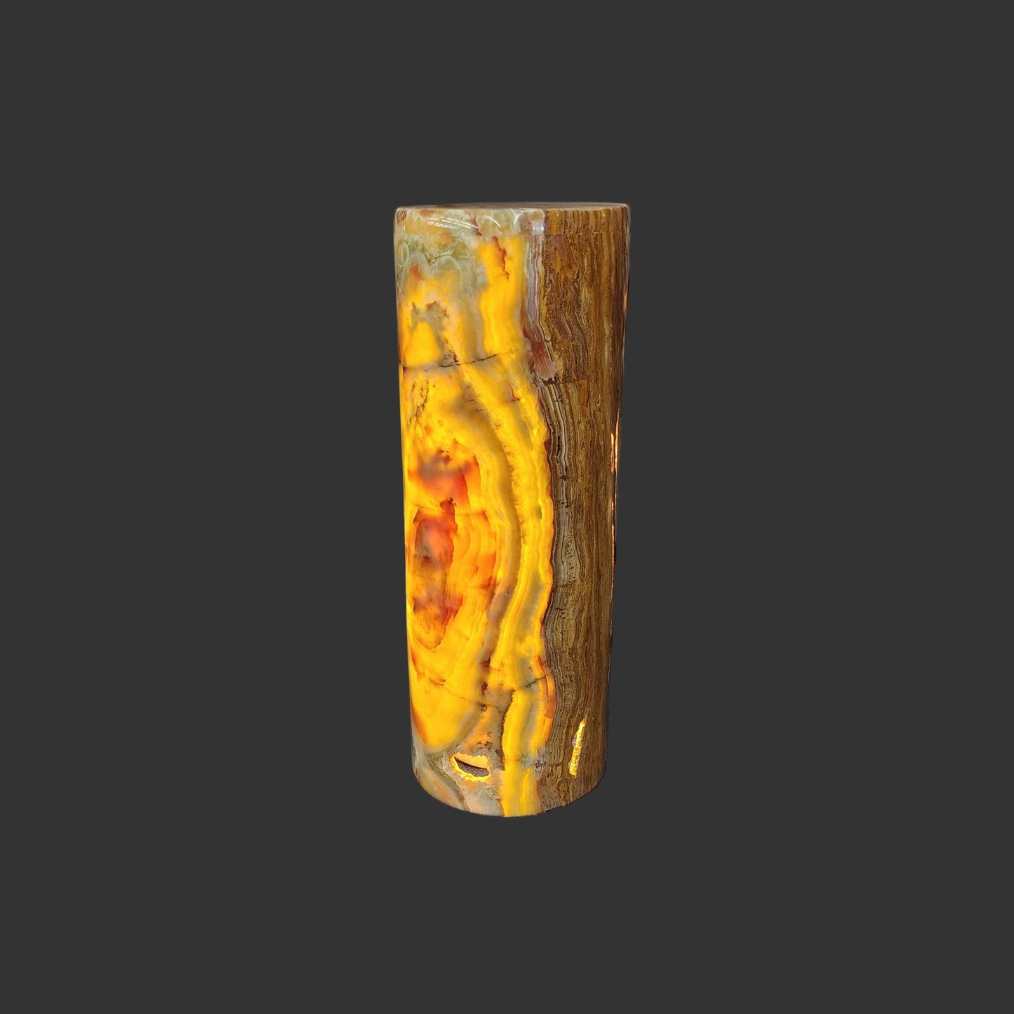 This is the polished onyx cylinder lamp with the lamp turned on