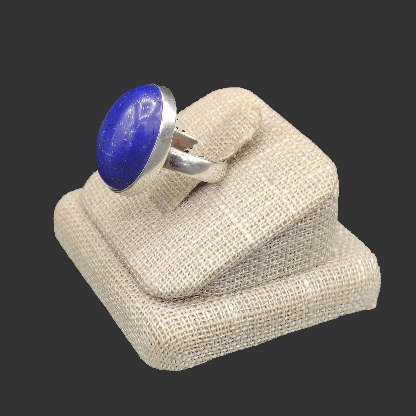 Close up of this blue Lapis and sterling silver ring on a beige ring stand.