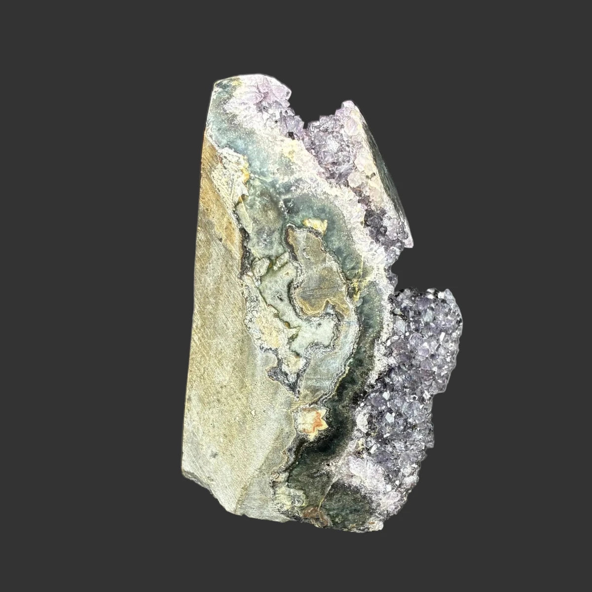 Right side of this purple amethyst cut base specimen, in front of a black background.