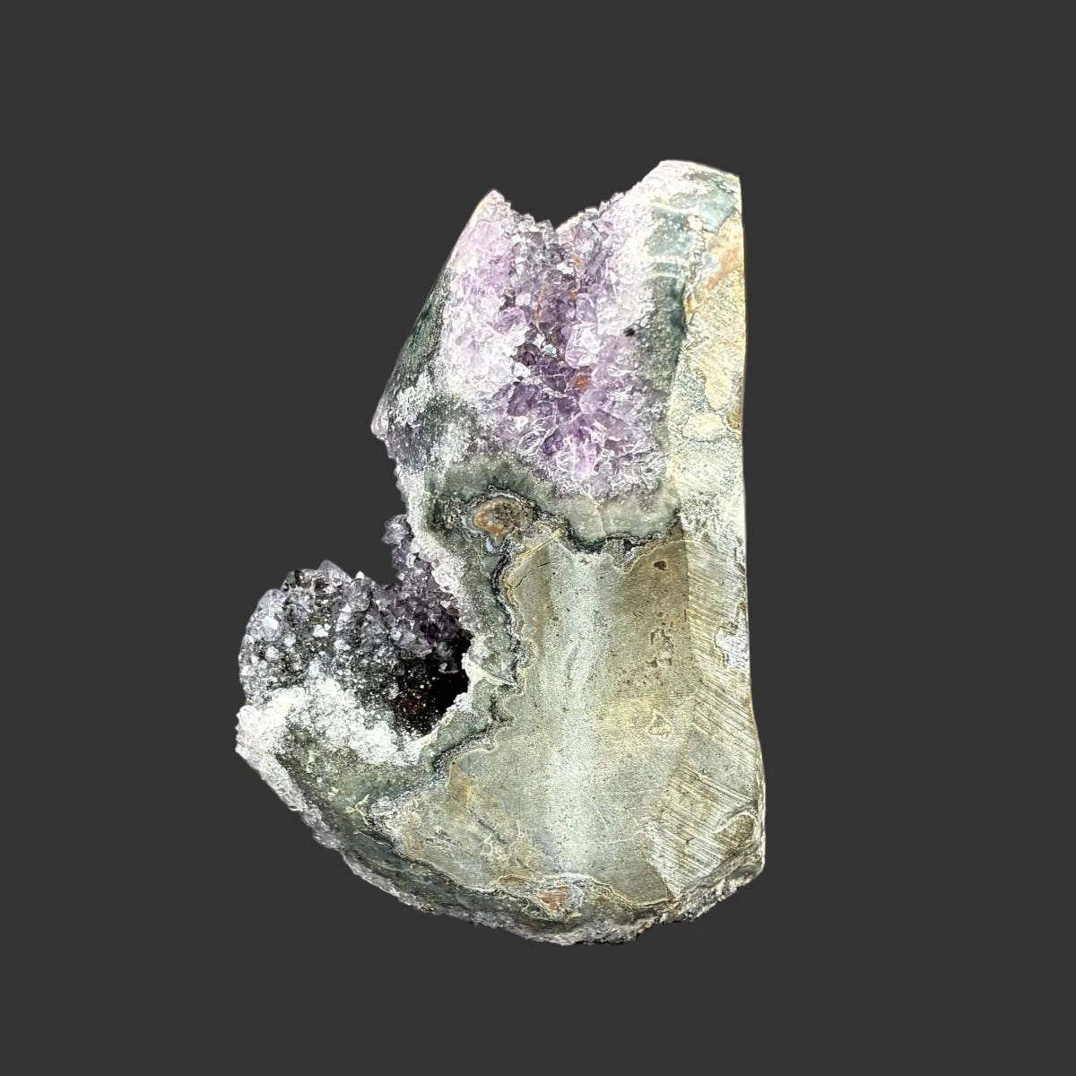 Left side of this purple amethyst cut base specimen, in front of a black background.