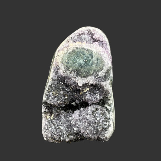 Front side of this purple amethyst cut base specimen, in front of a black background.