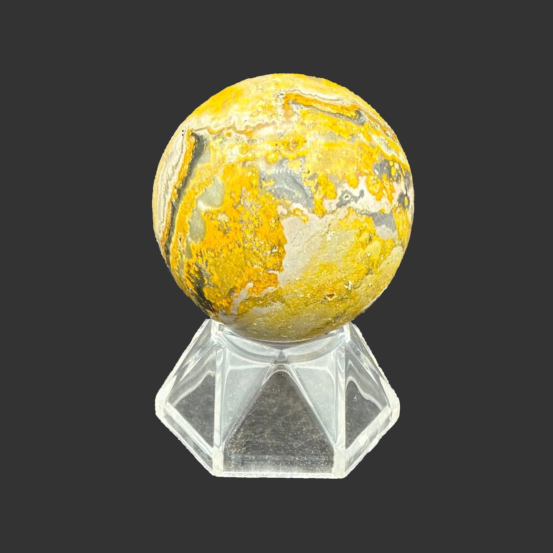 This is the left side of this polished Bumblebee Jasper sphere, in front of a black background.
