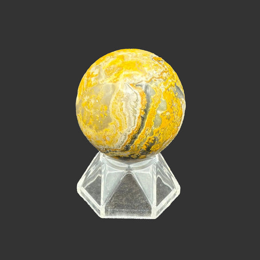 This is the front side of this polished Bumblebee Jasper sphere, in front of a black background.
