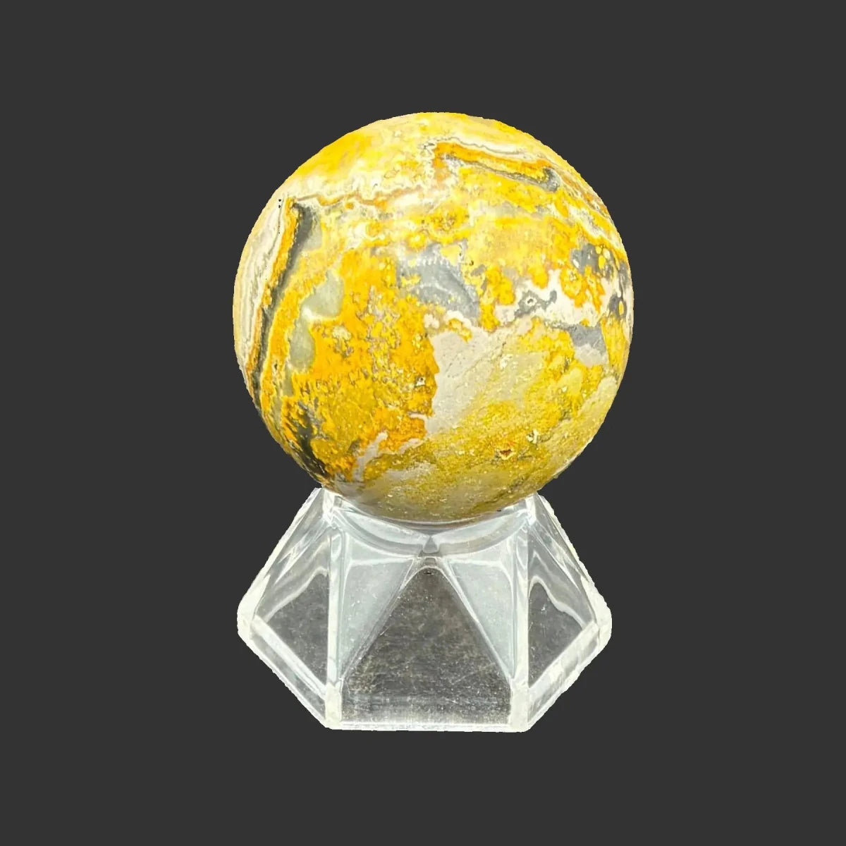 This is the left side of this polished Bumblebee Jasper sphere, in front of a black background.