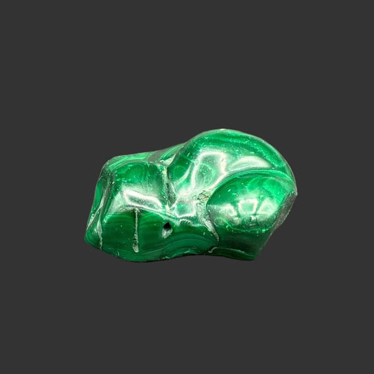 Front view of this polished malachite specimen, in front of a black background.