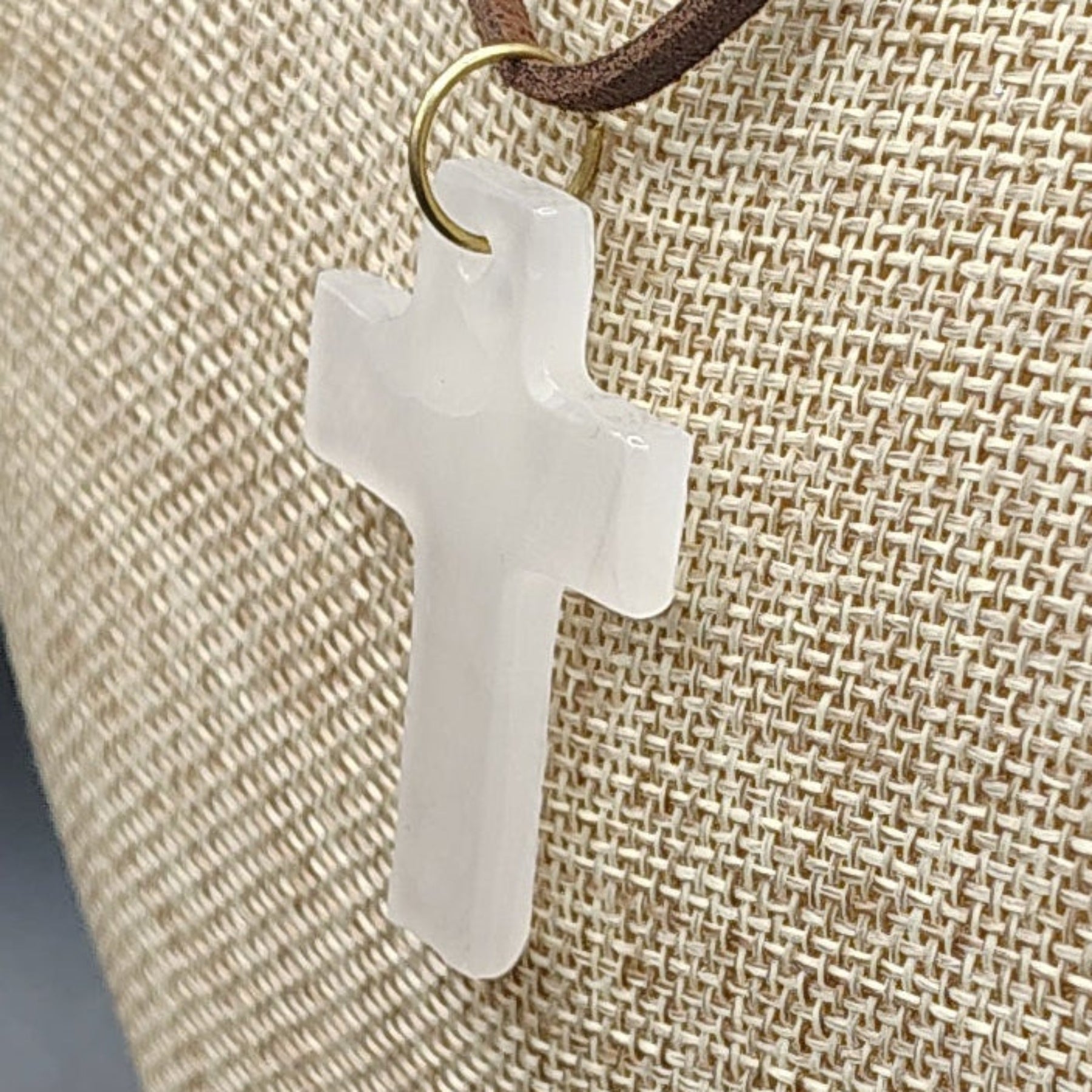 This is a close up of the polished cream-colored Onyx cross pendant.