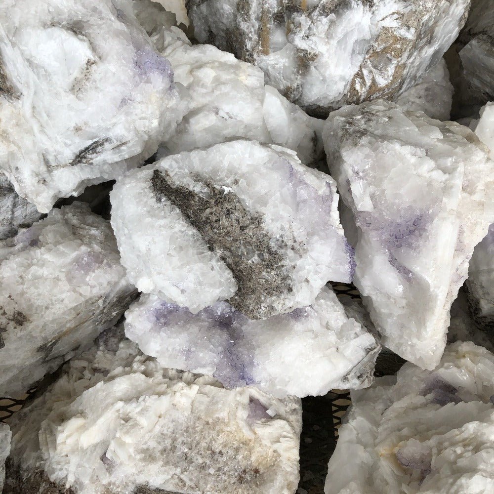 Purple Fluorite On Selenite Uncut Stone on a table