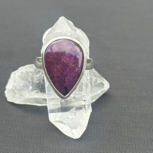 Top View Of Purpurite Stone Ring With Quartz Points In The Background