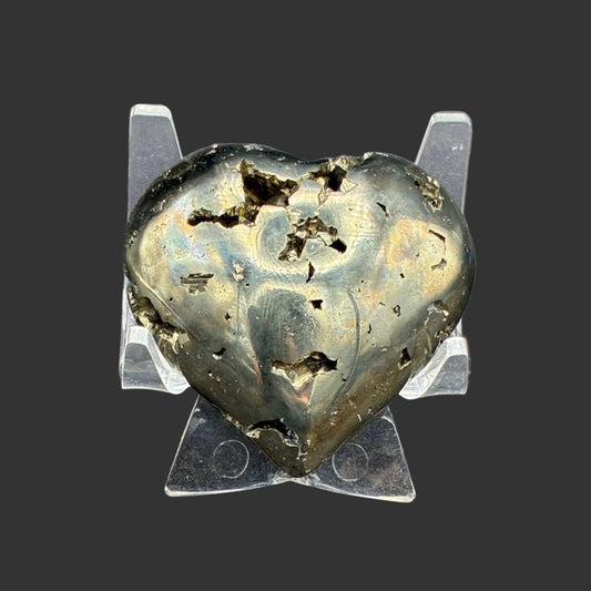Front Side of this polished gold Pyrite heart, in front of a black background and in a acrylic stand.