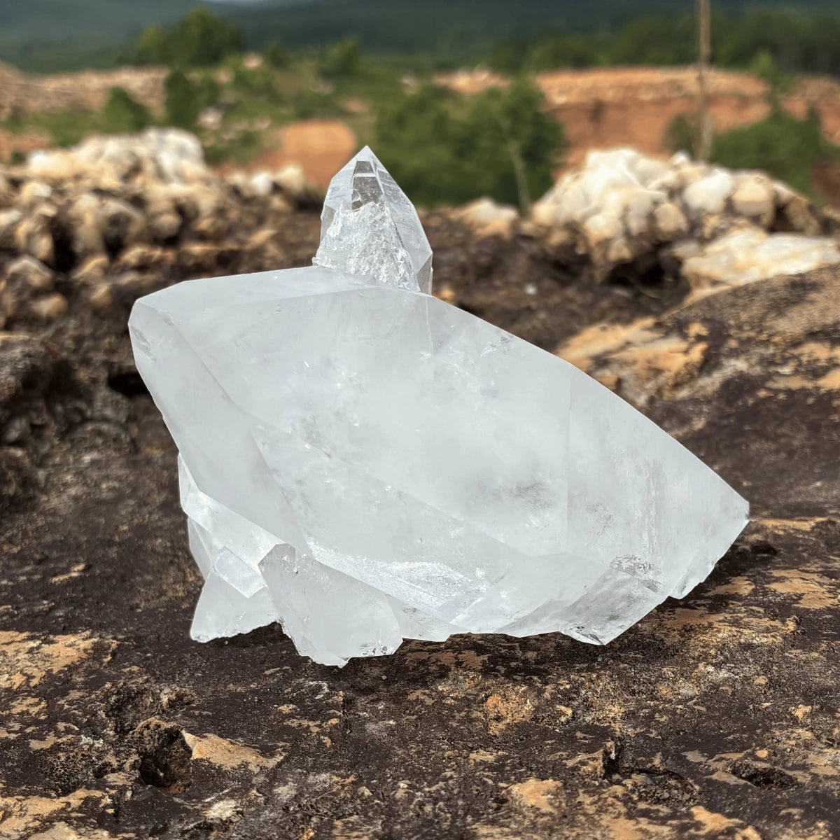 Back side ot this Quartz crystal cluster, in front of a outdoor setting.