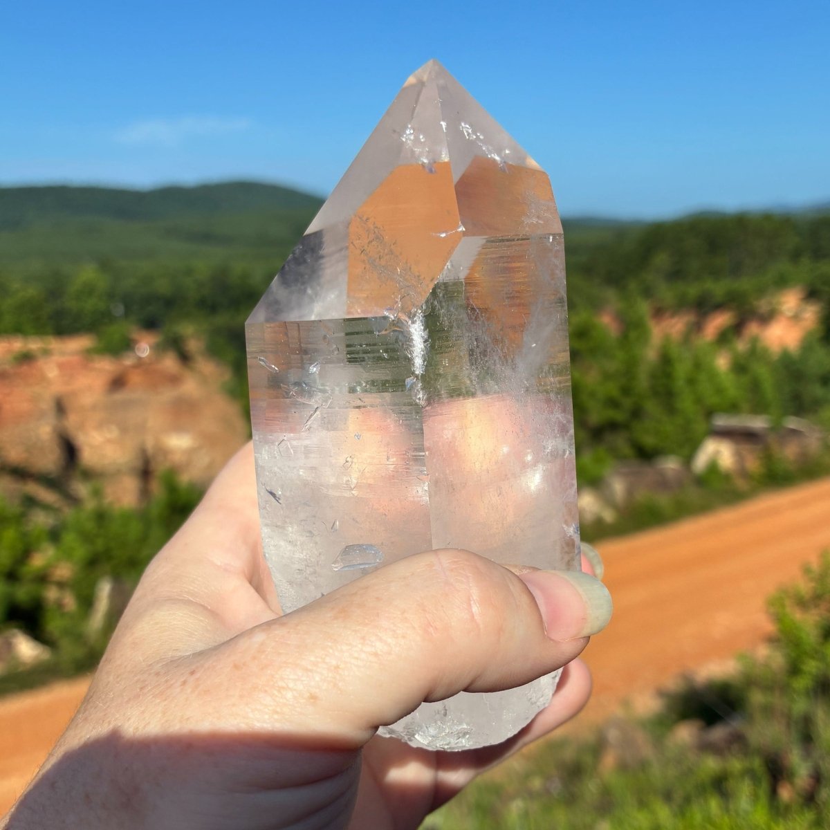 Left side of this water clear quartz crystal point, in a outdoor setting.