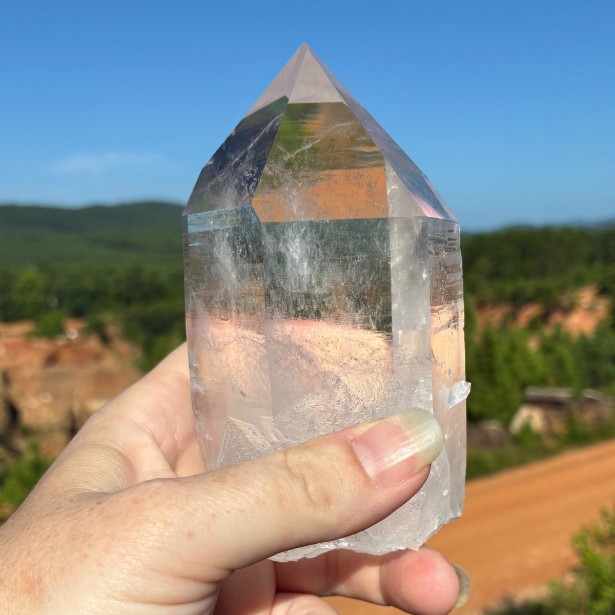 Front side of this water clear quartz crystal point, in a outdoor setting.