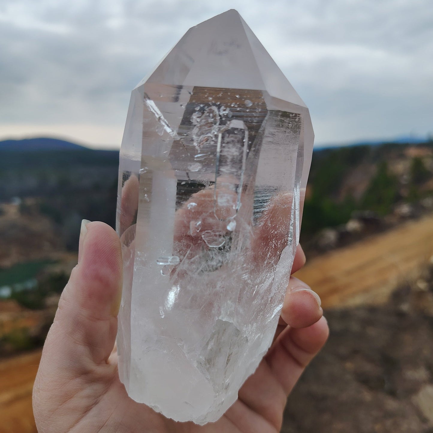 the back side of this water clear Quartz crystal point with a long tabby crystal attached to this side.