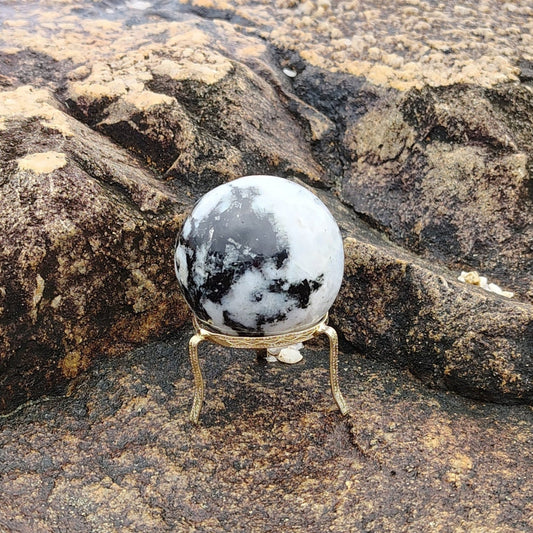 This is a polished rainbow moonstone sphere in natural light