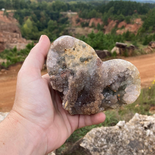 Heart shaped raw Amethyst specimen outside in natural light.