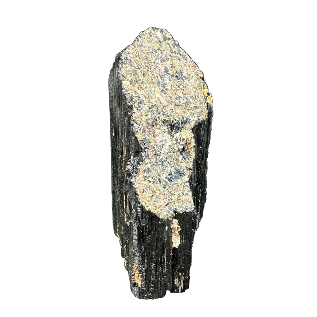 Right side of this raw black Tourmaline cut base piece, in front of a white background.