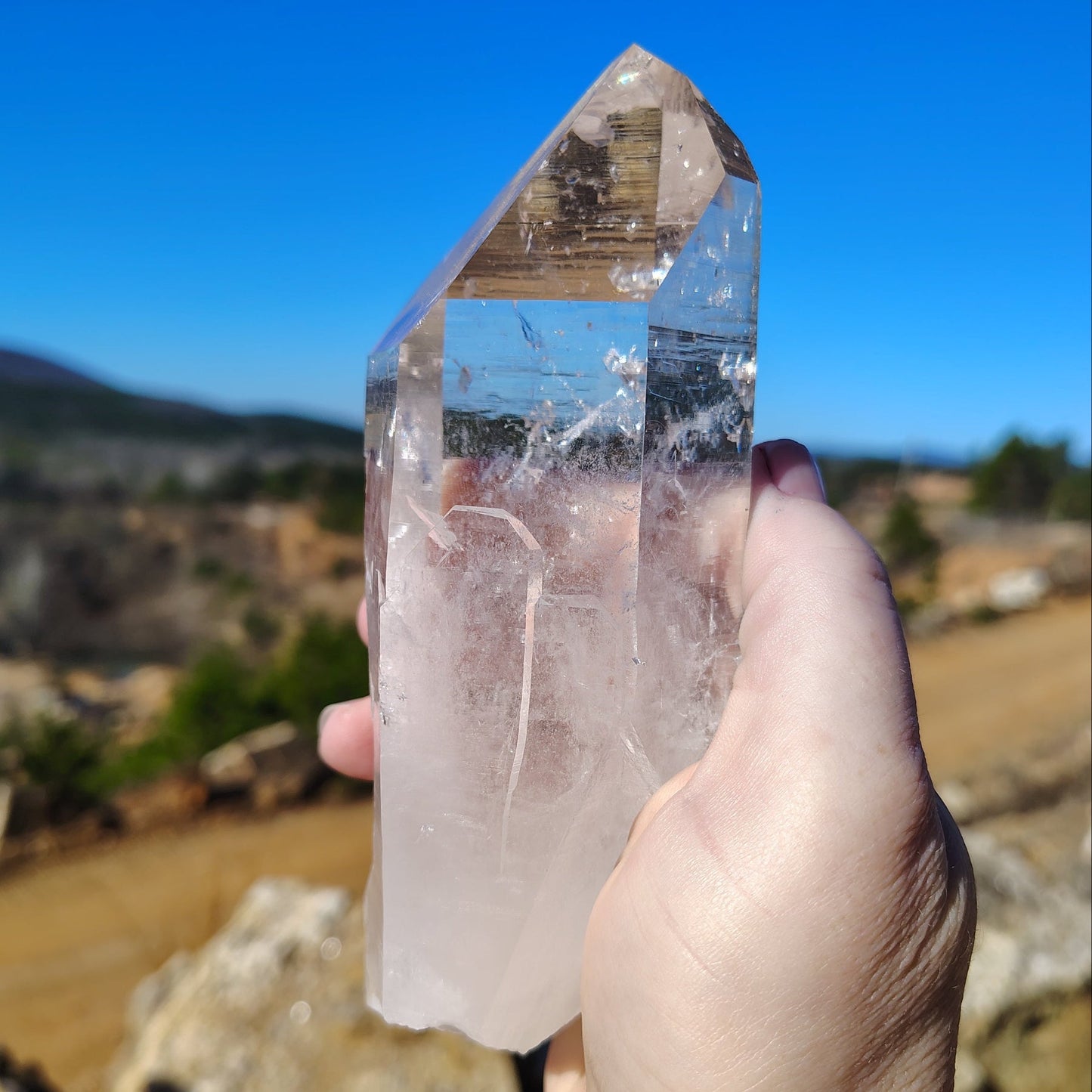 The left side of this pristine clear quartz crystal point in front of the Ron Coleman Crystal mine.