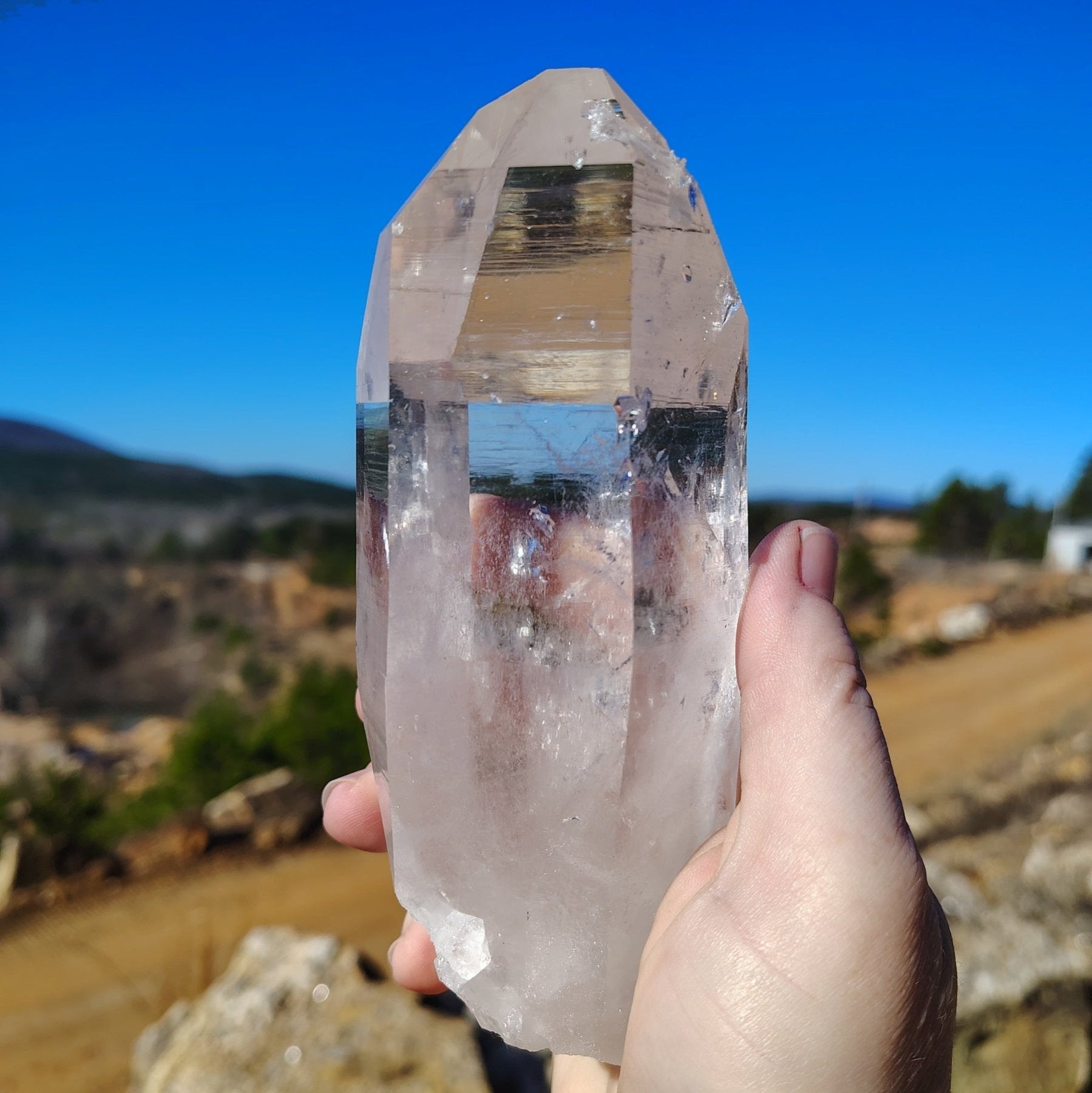 Back side of this pristine clear quartz crystal point in front of the Ron Coleman crystal mine.