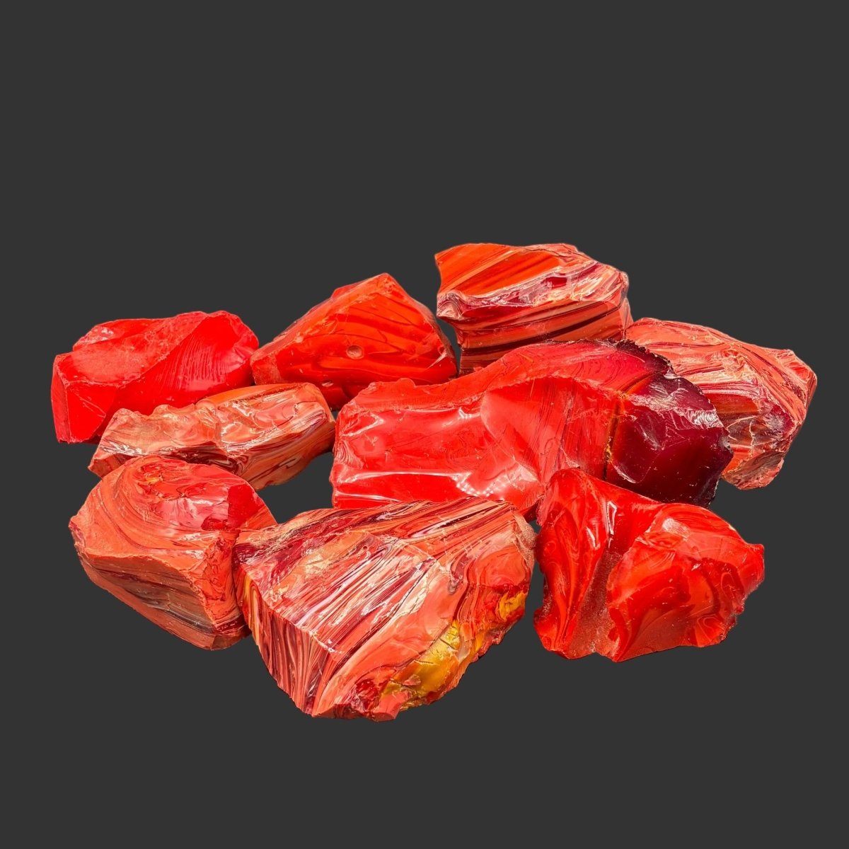 Group picture of all the red orange slag glass included, in front of a black background.