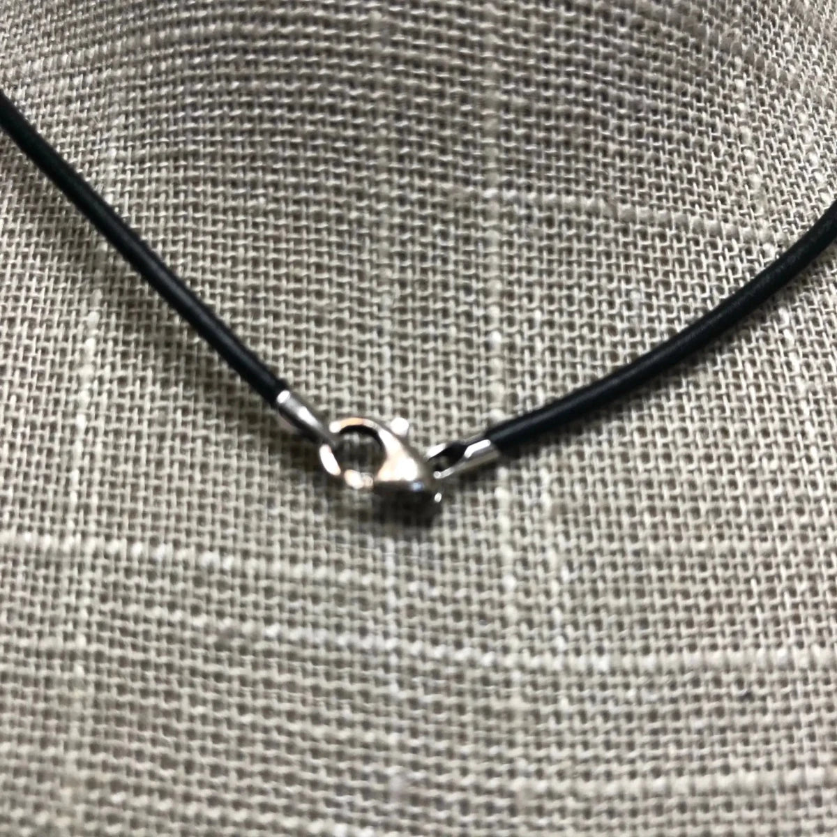 Close Up Of Black Cord Necklace On a Burlap Display