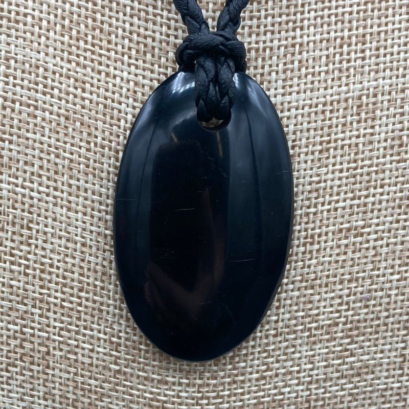 Close Up Of Shungite Pendant. Oval Shaped, Polished, and Black.