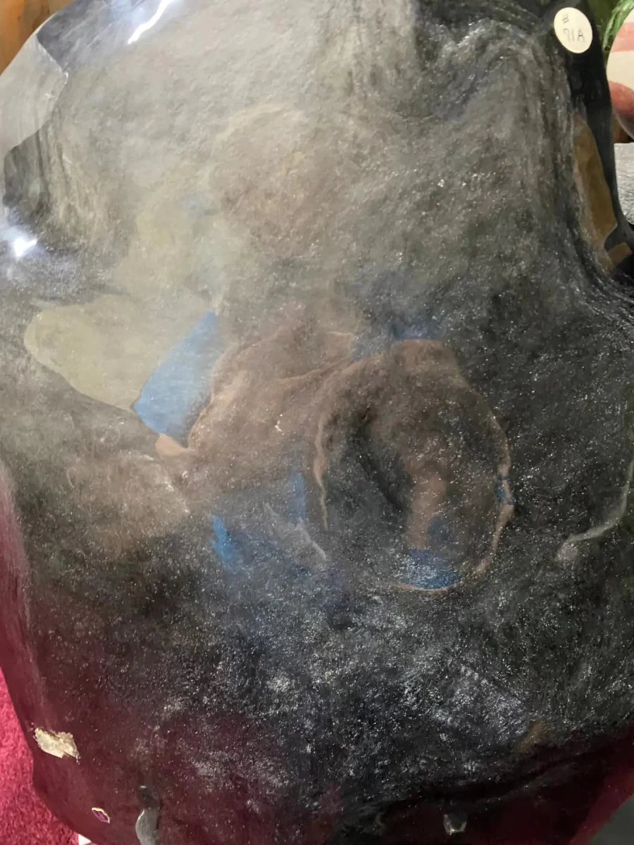 Close up silver sheen obsidian specimen displaying gray, black, blue tones