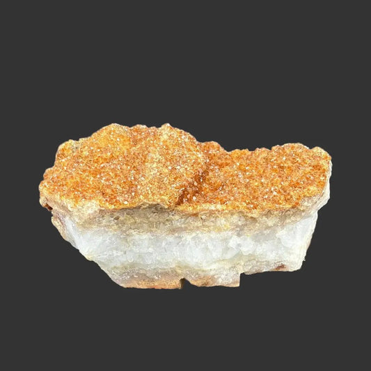 Front side of this small Citrine specimen, in front of a black background.