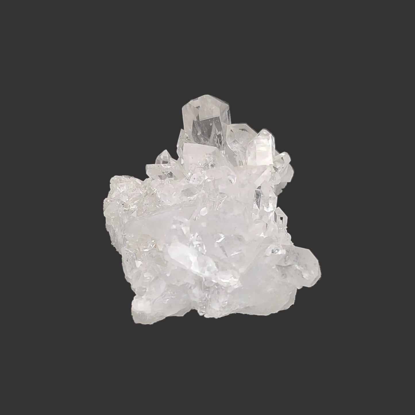 This is the right side of this clear small Quartz crystal cluster in artificial light.