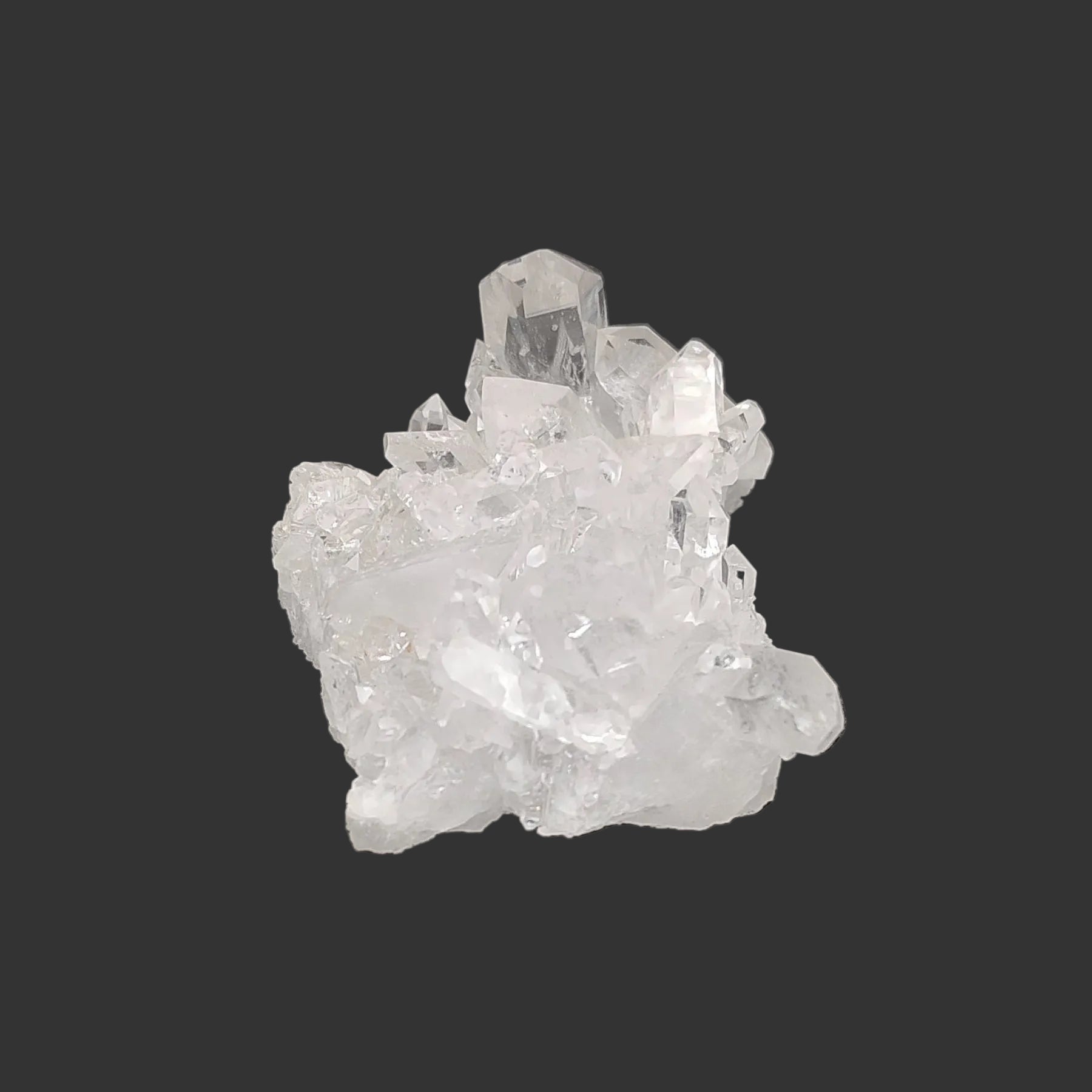 This is the right side of this clear small Quartz crystal cluster in artificial light.