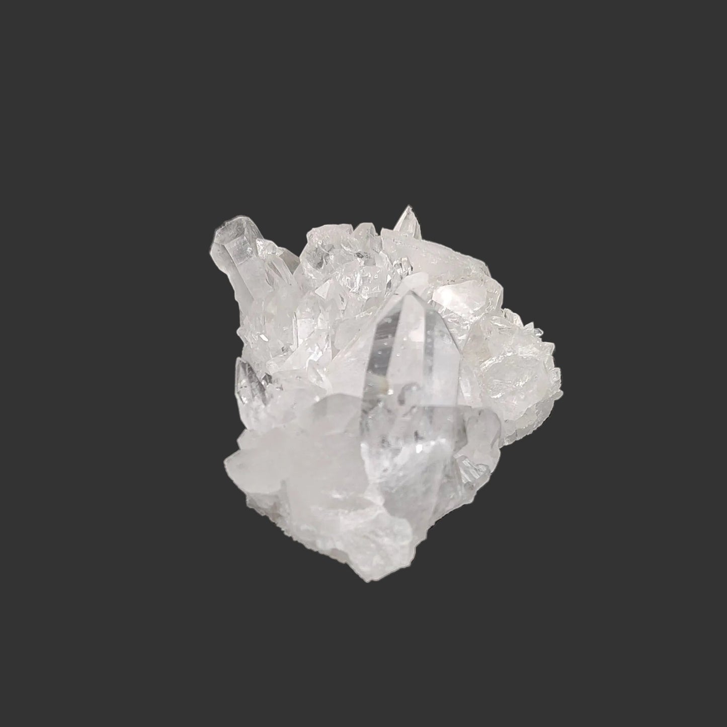 This is the left side of this small clear Quartz crystal cluster in artificial light.
