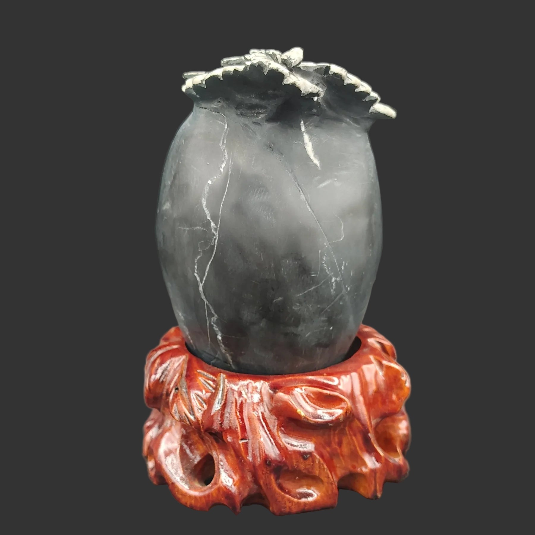 This is the back side of this Chrysanthemum stone, mostly black in color and the wooden stand is red.