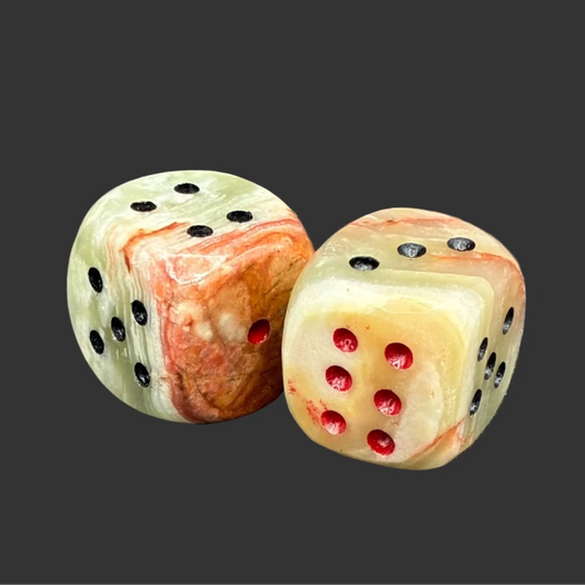 Banded onyx dice set in front of a black background.