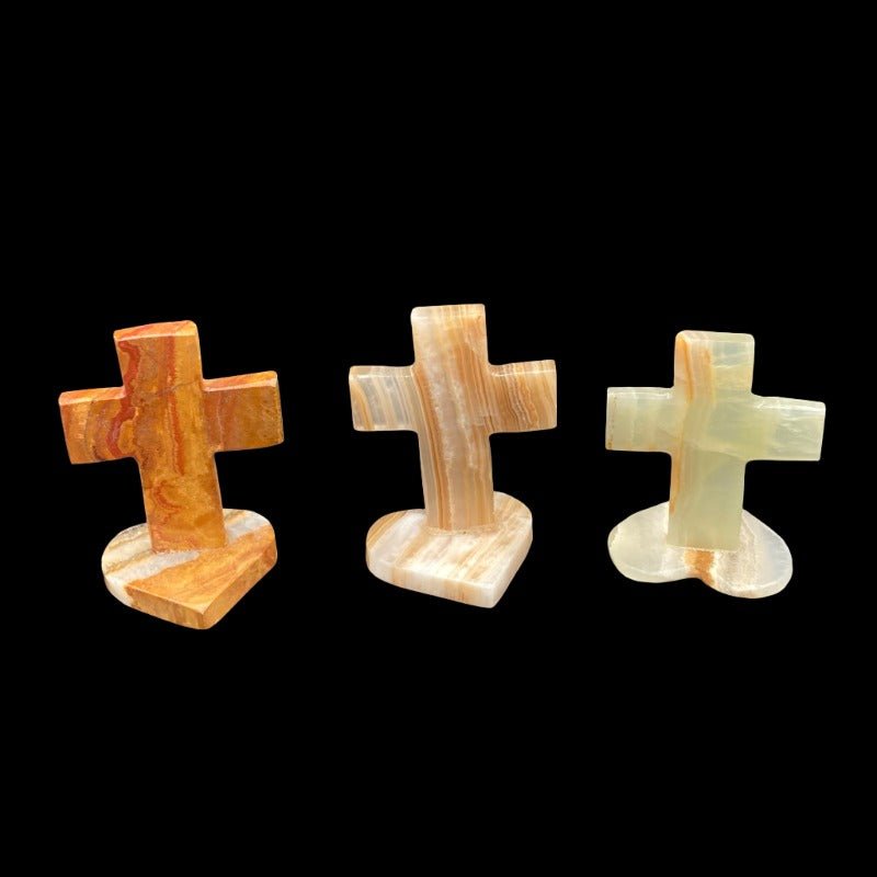 All Varietys Of Small Onyx Crosses With Heart Shaped Base. Starting From The Left, First We Have The Mostly Brown In Color. In The Middle Is The Brown And Cream Colored Cross. Then The Last One On The Far Right Is Mostly Cream In Color.