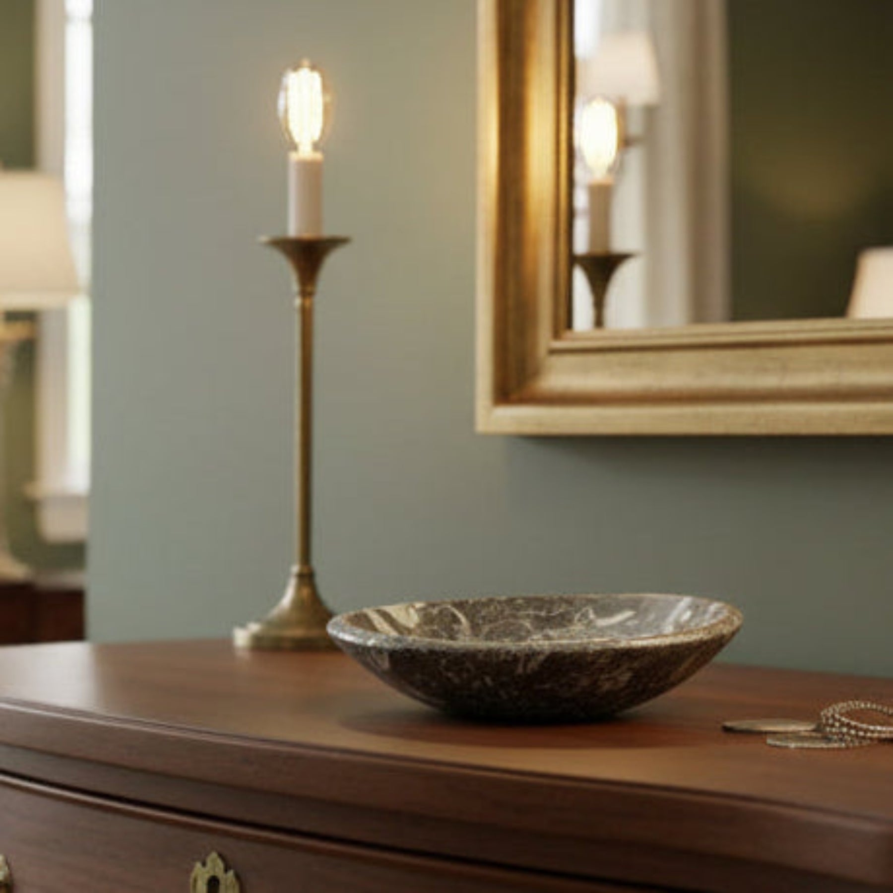 Small trinket bowl with authentic 
Ammonite fossils throughout, on top of a dresser.