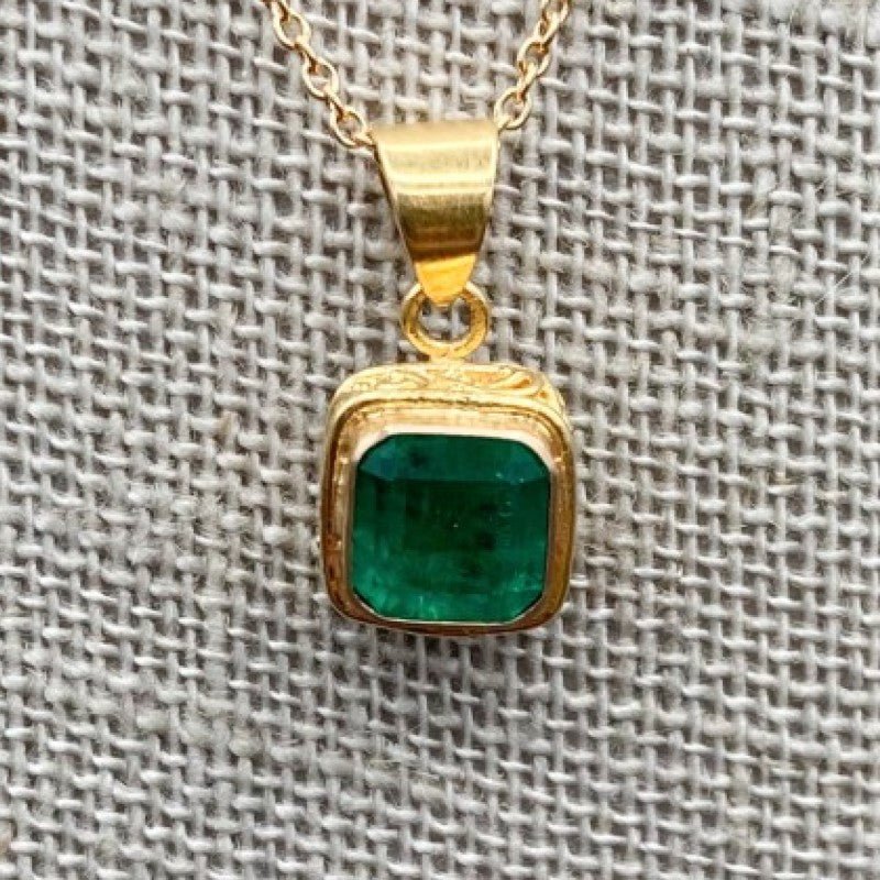 Close Up Of Green Emerald Pendant On Gold Necklace