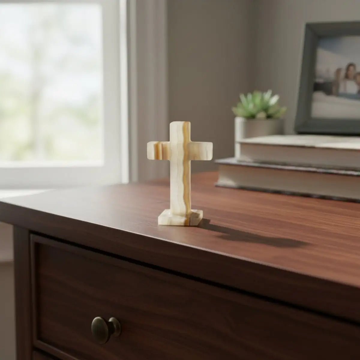 Polished banded Onyx cross sitting on top of a dresser.