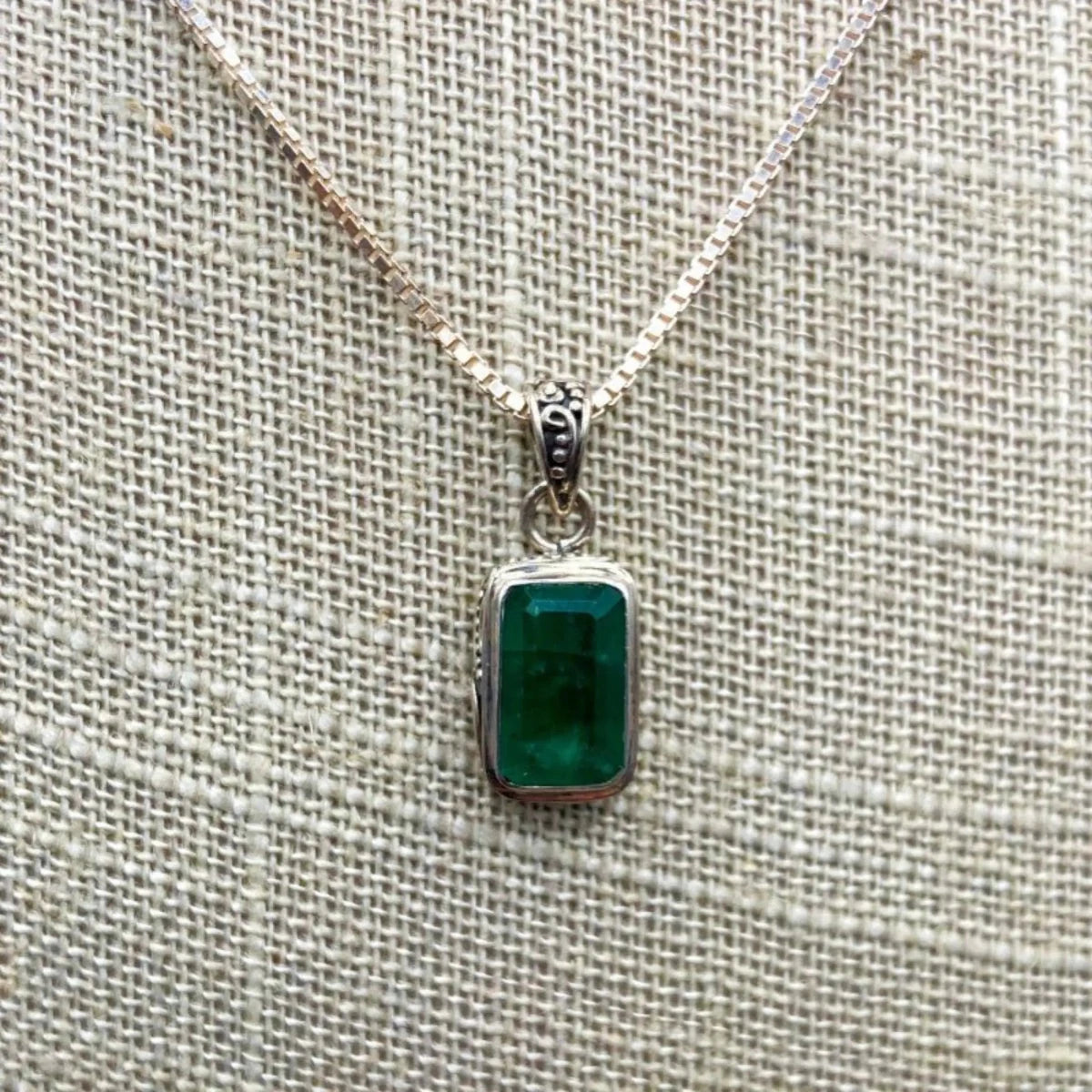 Close Up Of Deep Green Emerald Gemstone And Box Chain