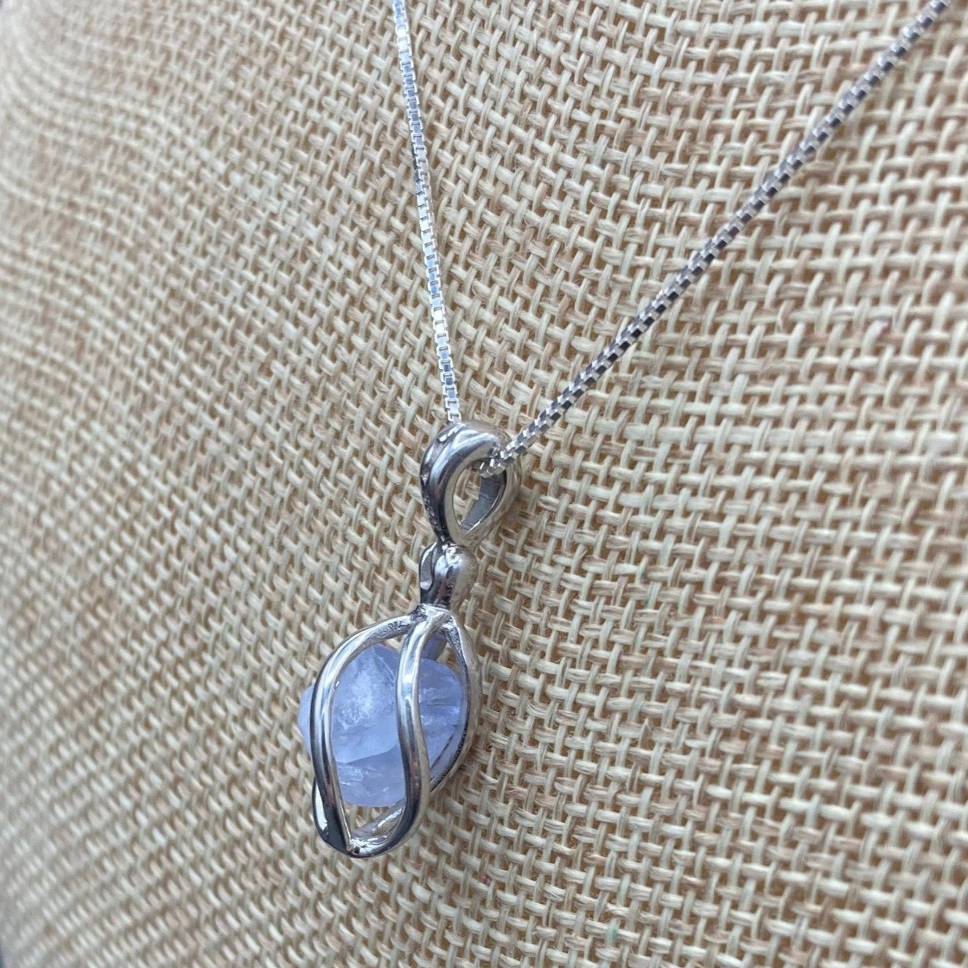 Up close side view of Quartz in Sterling Silver cage pendant