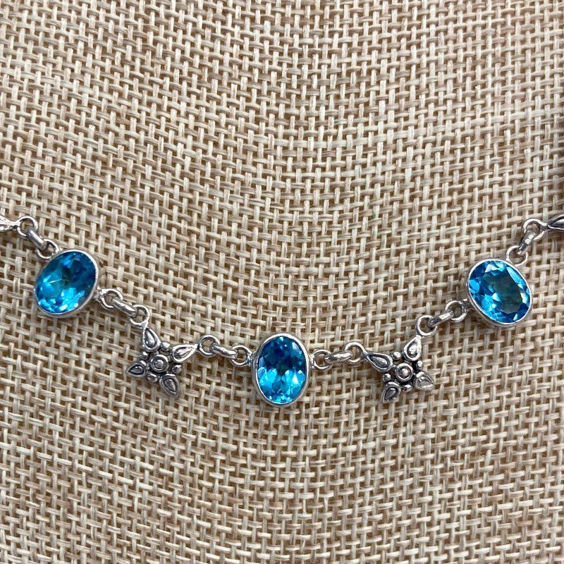 Close Up Of Blue Topaz Gemstone And Flower Necklace