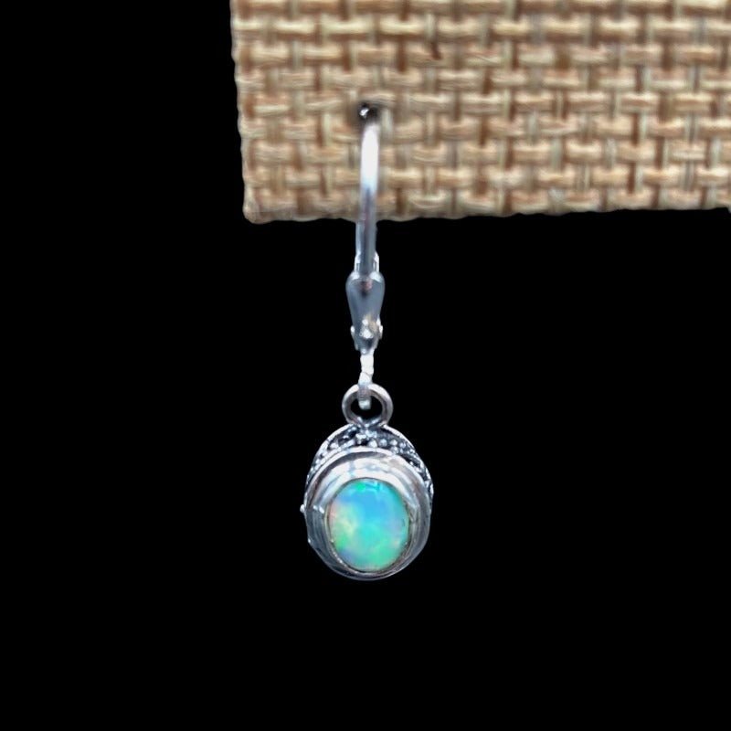 Close Up Of Sterling Silver Opal Gemstone Dangle Earrings, The Sterling Silver Setting Has A Paisley Design And The Gemstone Is Oval In Shape With A Clear, Blue, And Green Iridescent Hue