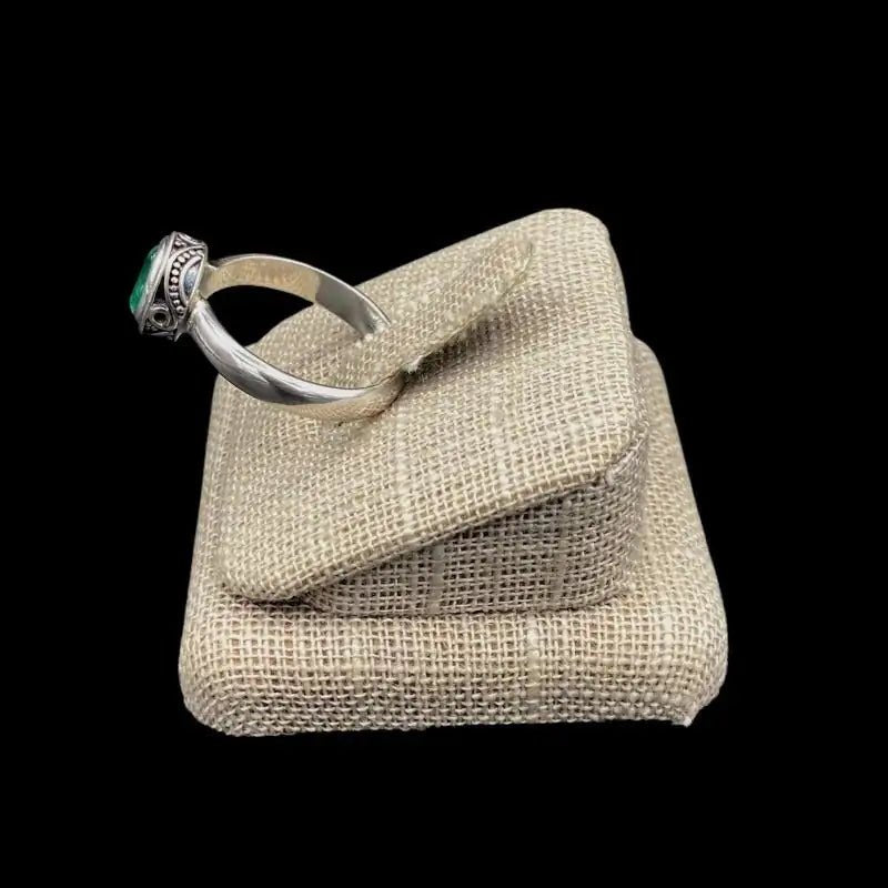 Side View Of Sterling Silver Oval Emerald Gemstone Ring, Band Is Polished Smooth Silver And The Setting Has A Paisley Design