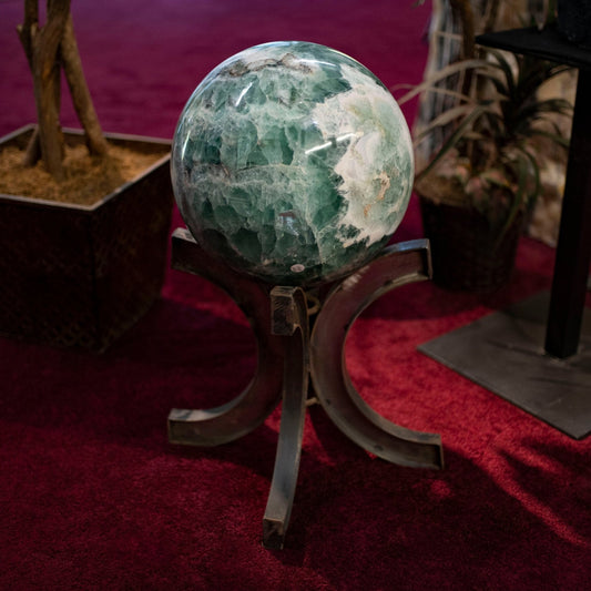 Flourite Sphere On Wooden stand with other minerals in background