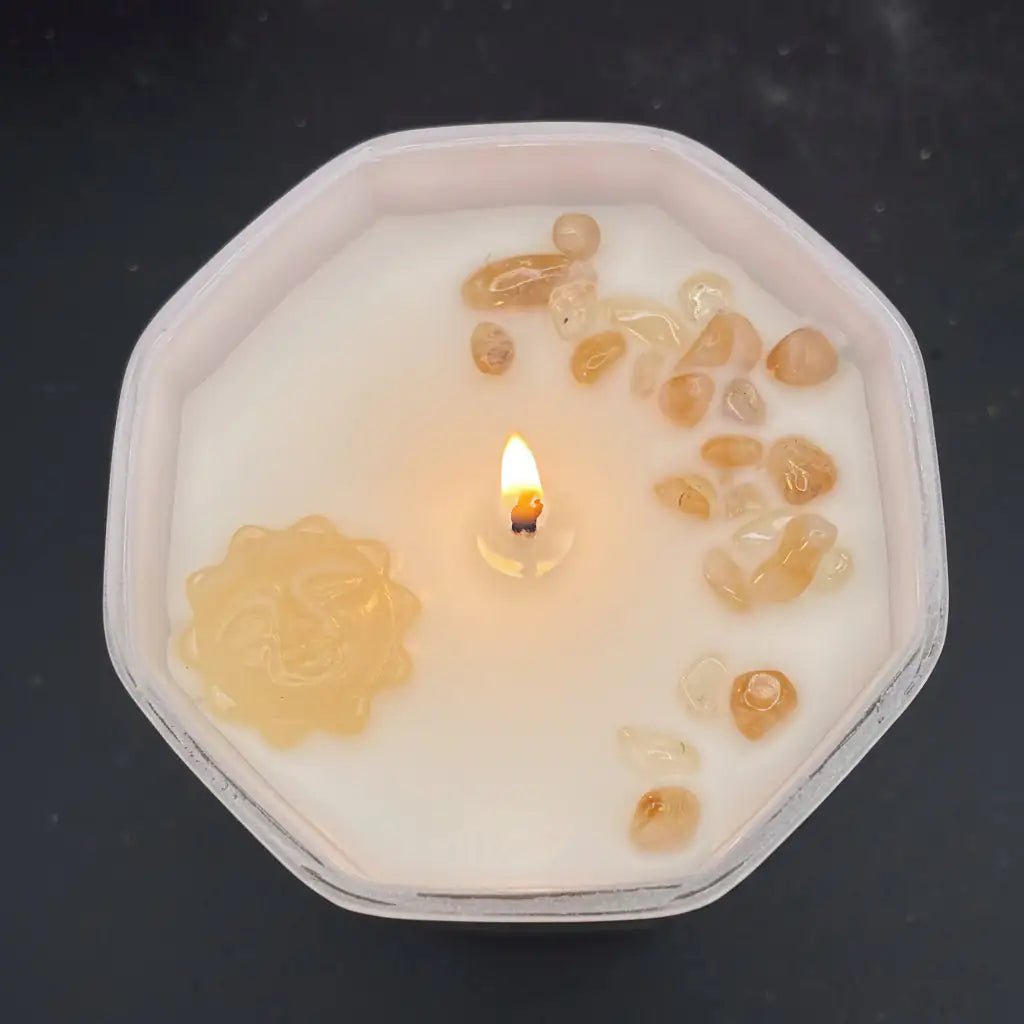 Top view of this sun candle while lite, showing the yellow Jade sun pendant and Citrine chips.