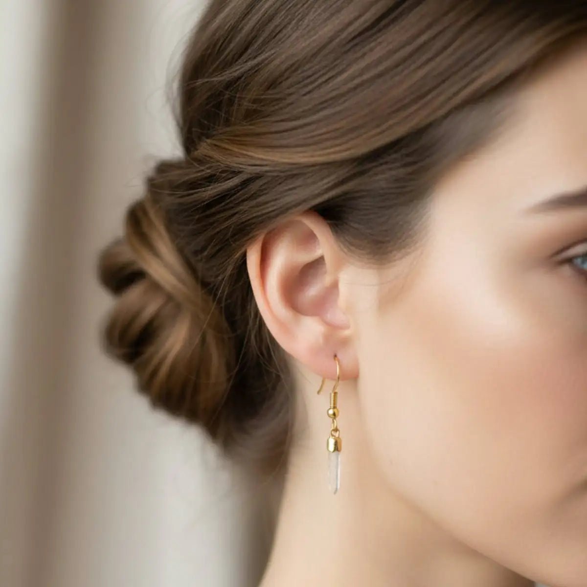 Gold Tibetan quartz crystal point earrings on a lady.